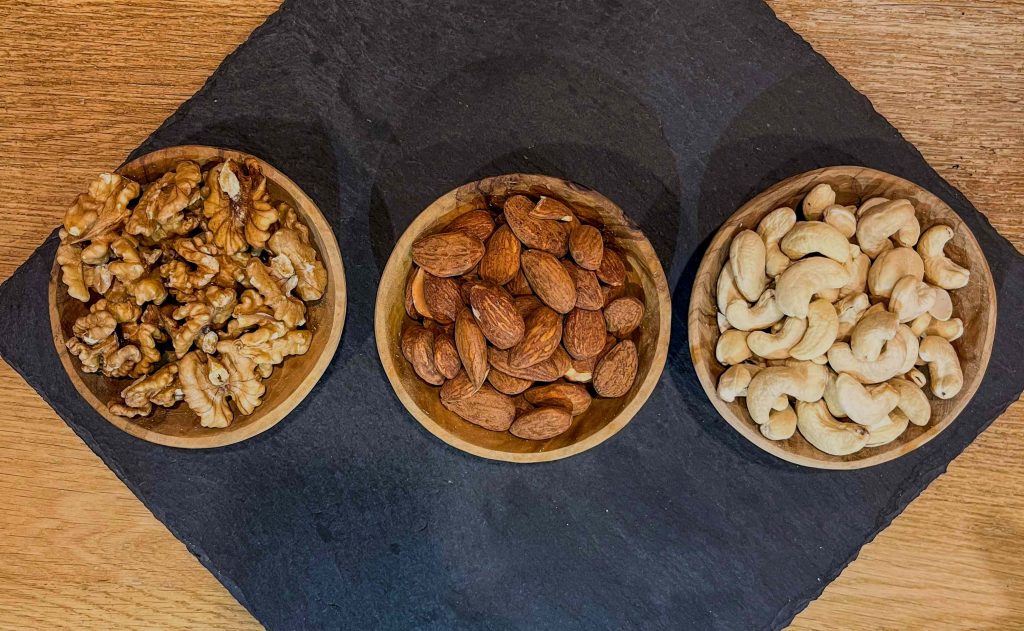 Frutta secca sfusa in ciotole di legno: noci, mandorle e anacardi — Antica Spesa Torino